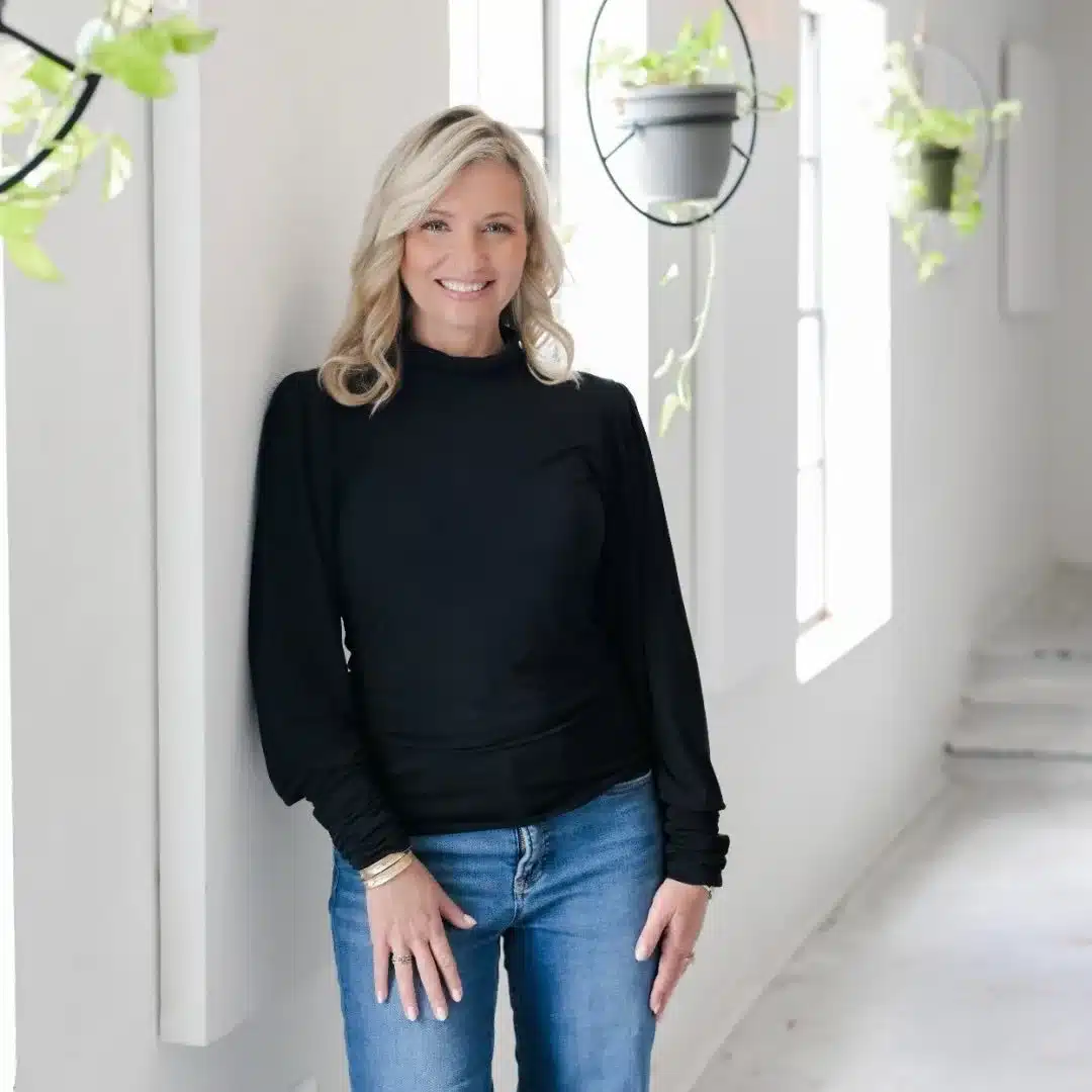 Deborah Nicosia, Florida Realtor with RE/MAX Champions, standing in a bright modern interior space, smiling confidently